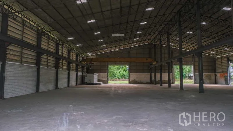 Factory for rent in Bang Phli, Samut Prakan - Wide clear-span factory space with high clearance and rear loading opening to a green yard.