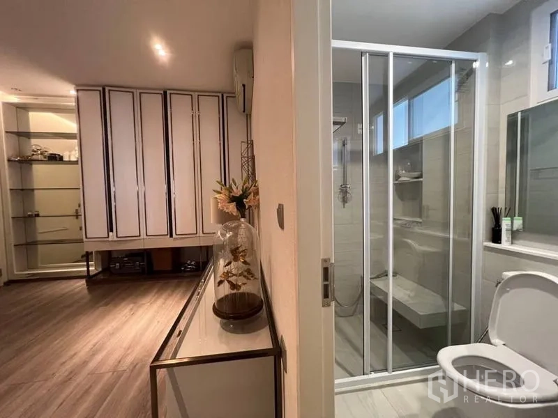 Detached House for rent or sale in Bang Phli, Samut Prakan - Contemporary bathroom with glass shower enclosure and vanity storage.