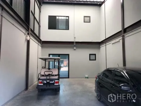 Warehouse for rent in Bang Phli, Samut Prakan - Double-height warehouse interior with concrete floor and parking area beneath mezzanine office.