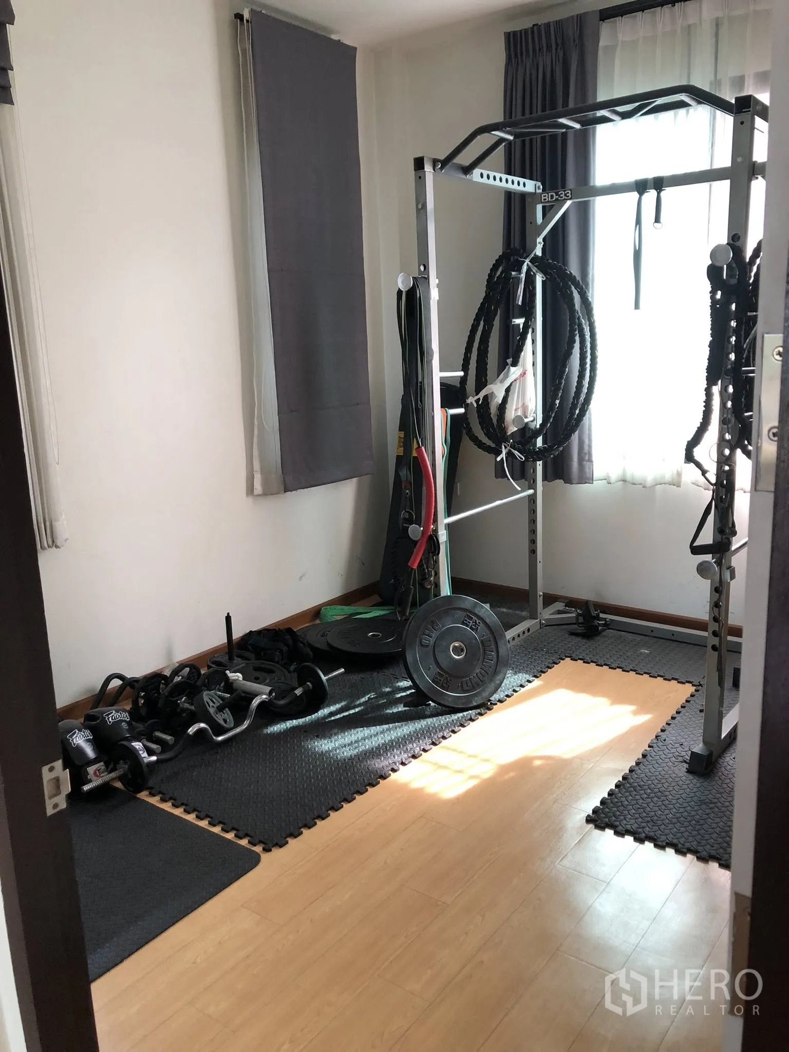 Townhouse for sale in Phra Khanong, Bangkok - Dedicated fitness room with power rack, dumbbells and protective floor mats.