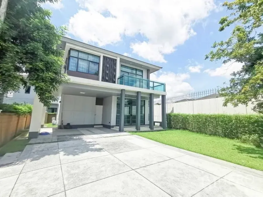 Detached House for rent or sale in Prawet, Bangkok - Modern two-storey house with balcony, tall pillars, carport and a green lawn.