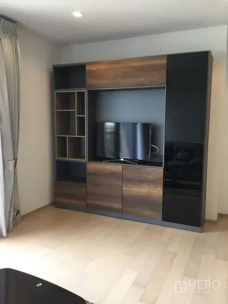 Condominium for rent in Watthana, Bangkok - Modern living room media wall with built-in TV cabinet and shelving.