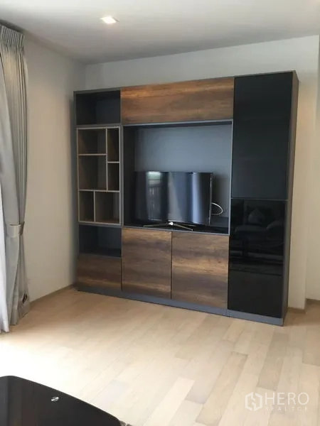 Condominium for rent in Watthana, Bangkok - Modern living room media wall with built-in TV cabinet and shelving.