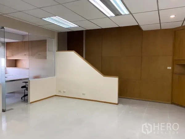 Office Space for rent in Din Daeng, Bangkok - Open-plan workspace with suspended lights, wood accent wall and adjacent glass-partitioned office.