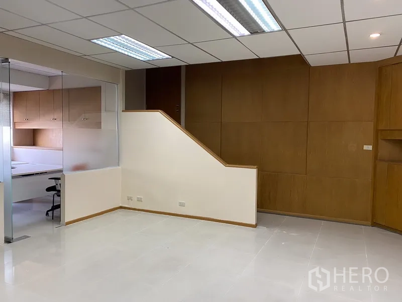 Office Space for rent in Din Daeng, Bangkok - Open-plan workspace with suspended lights, wood accent wall and adjacent glass-partitioned office.