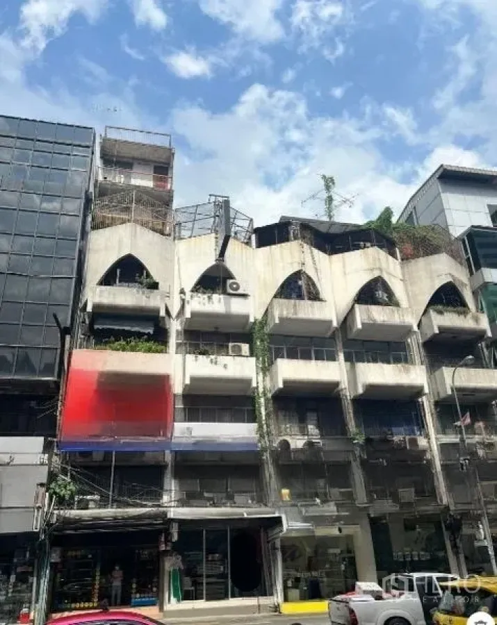 อาคารพาณิชย์ ขายในWatthana, Bangkok - ด้านหน้าอาคารพาณิชย์คอนกรีตสไตล์ช่องโค้ง เครื่องปรับอากาศและต้นไม้ ใกล้สถานีบีทีเอส นานา