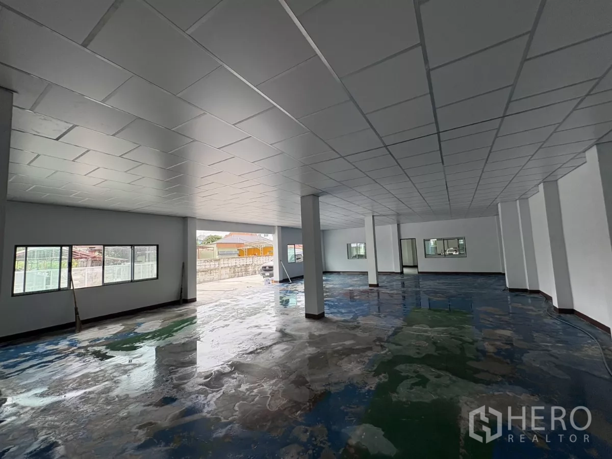 Factory for rent in Khlong Toei, Bangkok - Open-plan office or showroom with pillars and wide windows to the yard.