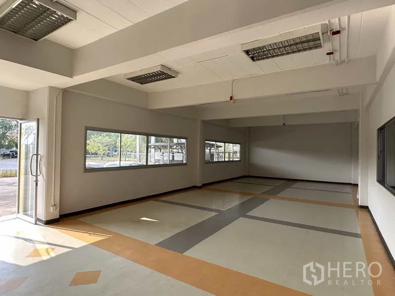 Factory for rent in Bang Phli, Samut Prakan - Ground-floor office space with large windows and patterned tile flooring.