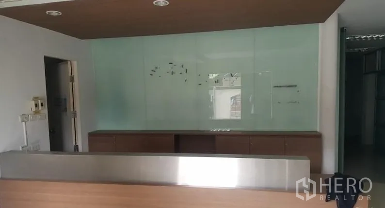 Warehouse for rent in Suan Luang, Bangkok - Front reception desk with glass feature wall and recessed ceiling lights.