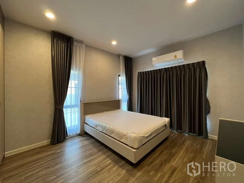 Detached House for rent in Bang Kapi, Bangkok - Bright bedroom with wood floors, air conditioning and blackout curtains.
