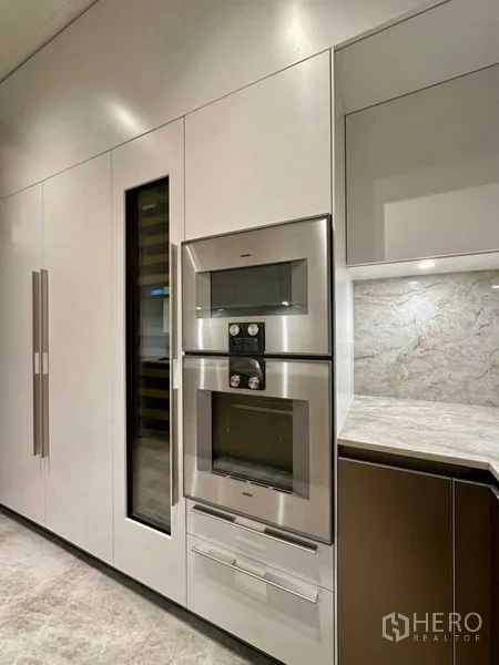 Condominium for rent or sale - Close-up of built-in stainless ovens and tall storage in the modern kitchen.