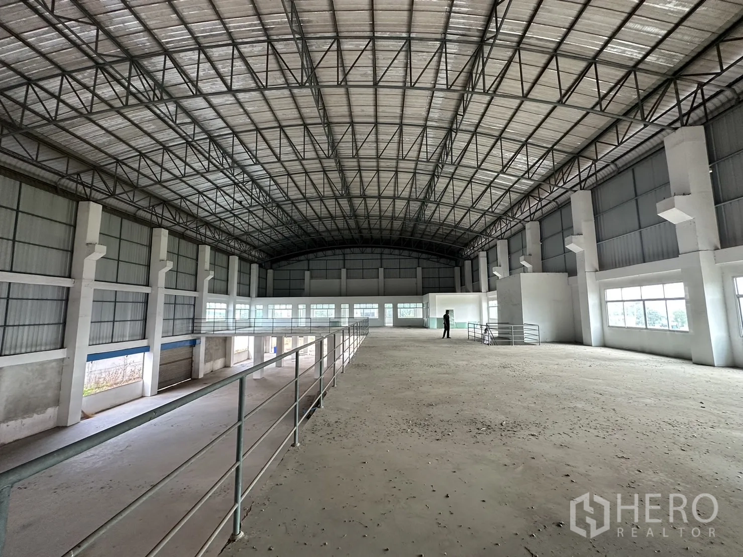 Factory for rent in Pak Kret, Nonthaburi - Mezzanine workspace with guardrails and windows running along the side wall.