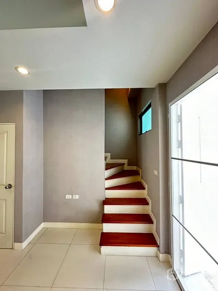 Townhouse for rent or sale in Phra Khanong, Bangkok - Wood-step staircase with side window leading to upper floors.