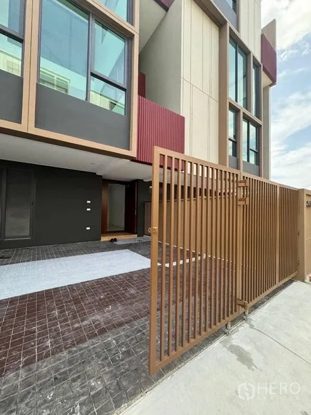 Townhouse for rent - Modern townhouse facade with full-height windows and metal gate on Sukhumvit 77.