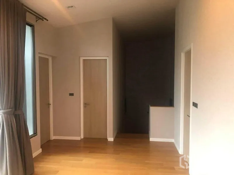 Detached House for rent or sale in Bang Kapi, Bangkok - Upstairs landing with three doors, wooden floor and a tall curtained window.
