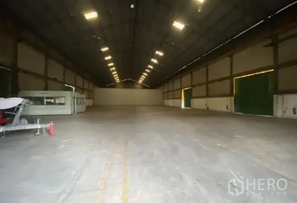Warehouse for rent in Mueang Pathum Thani, Pathum Thani - Spacious warehouse interior with high gable roof, bright lighting, and wide open floor area.