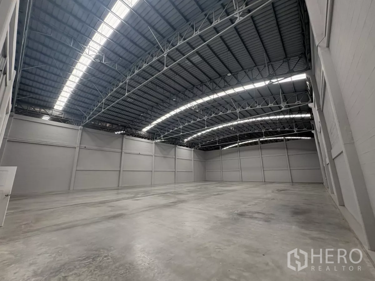 Factory for rent in Bang Phli, Samut Prakan - Wide-angle view of warehouse showing skylights and high clearance.