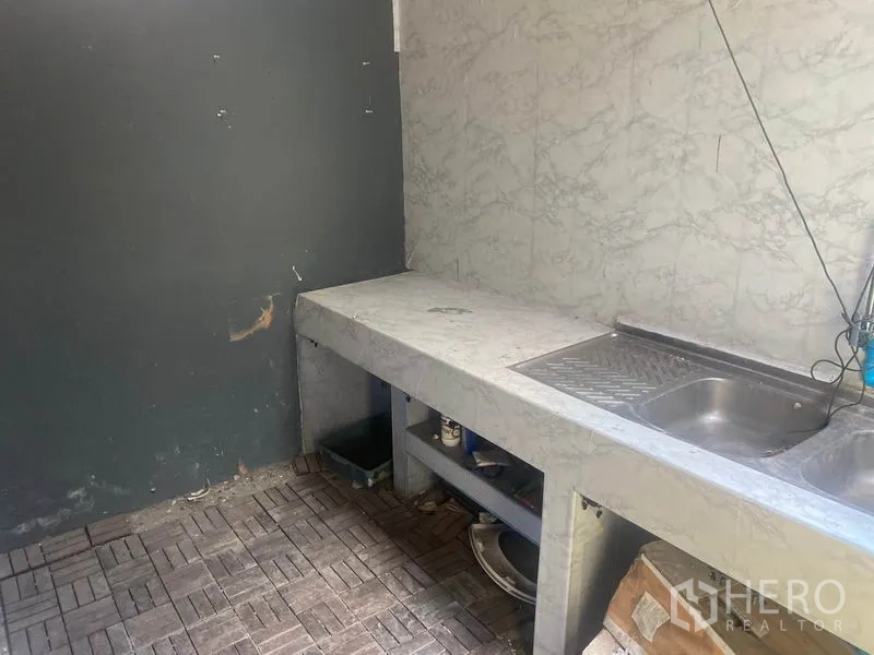 Shophouse for rent in Watthana, Bangkok - Basic back kitchen with concrete countertop, stainless sink and tiled walls