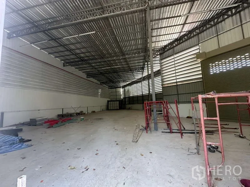 Warehouse for rent in Sai Mai, Bangkok - Deep warehouse bay with high ceilings, roller door, and utility-ready structure.
