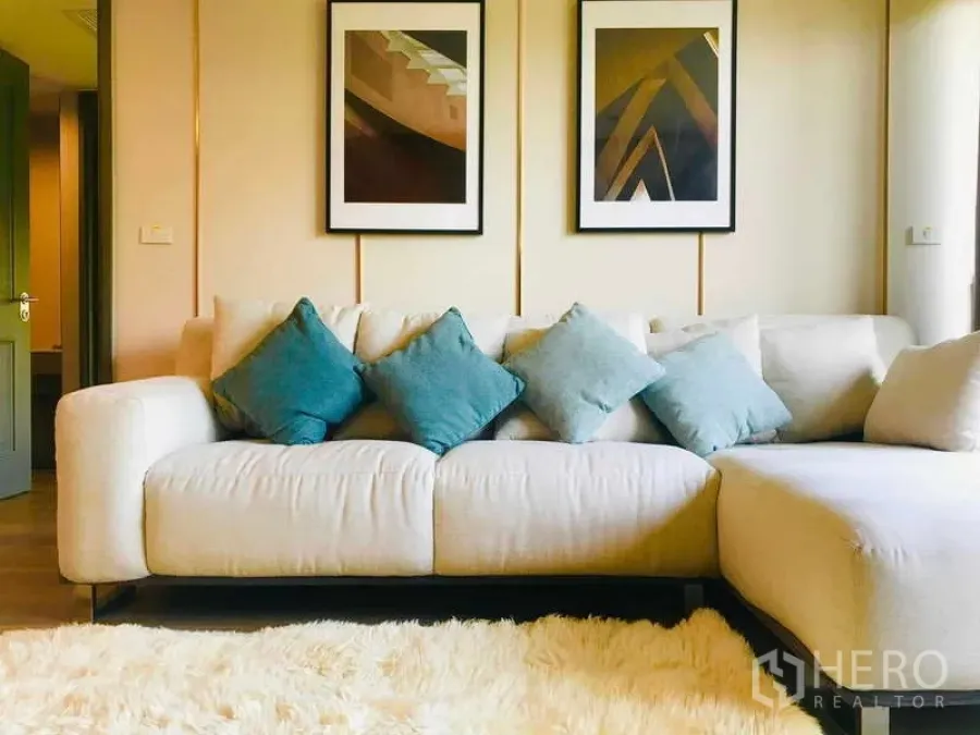 Condominium for rent - Cozy lounge area with sectional sofa, modern wall art and soft area rug.