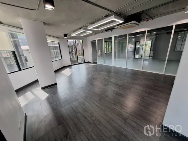 Office Space for rent - Corner office with wraparound windows, glass wall meeting room and dark floors.