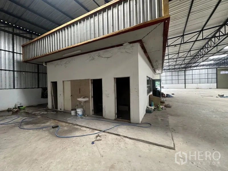 Warehouse for rent in Khlong Luang, Pathum Thani - On-site restroom and utility core within the warehouse, adjacent to the work area and parking.