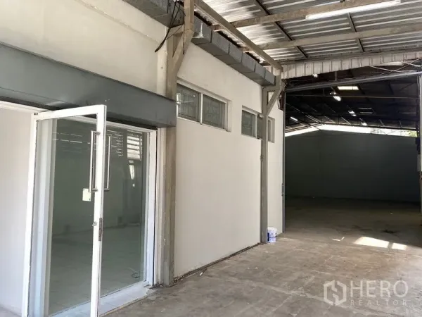 货栈 出租在Chatuchak, Bangkok - 玻璃门办公室入口，旁连金属屋顶的开阔仓库。