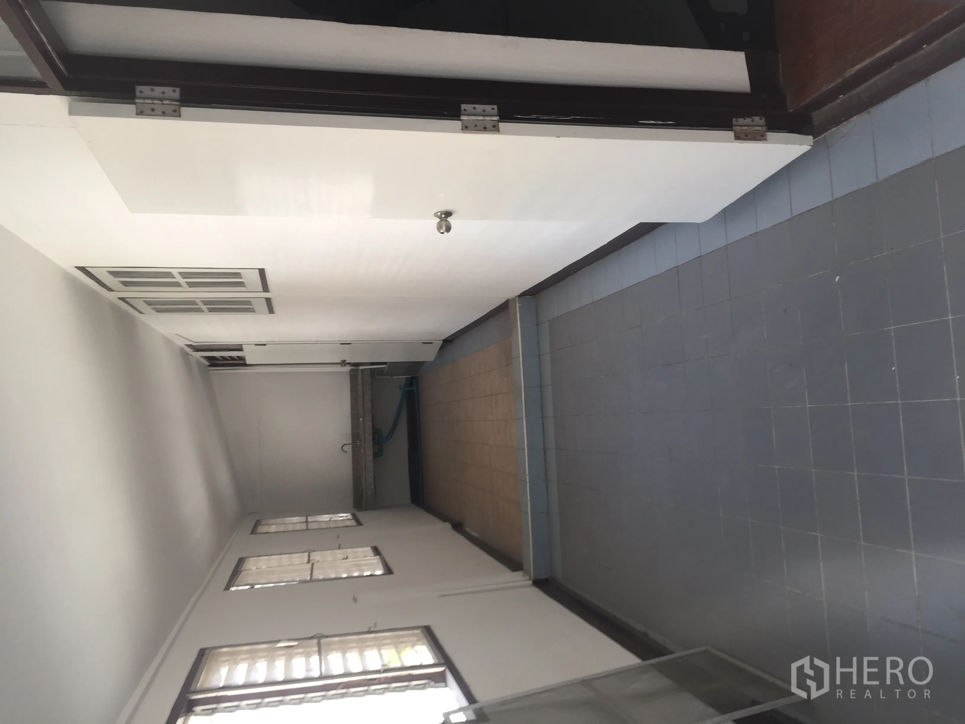 Home Office for rent in Watthana, Bangkok - Rear service corridor with tiled floor, sink and high windows.