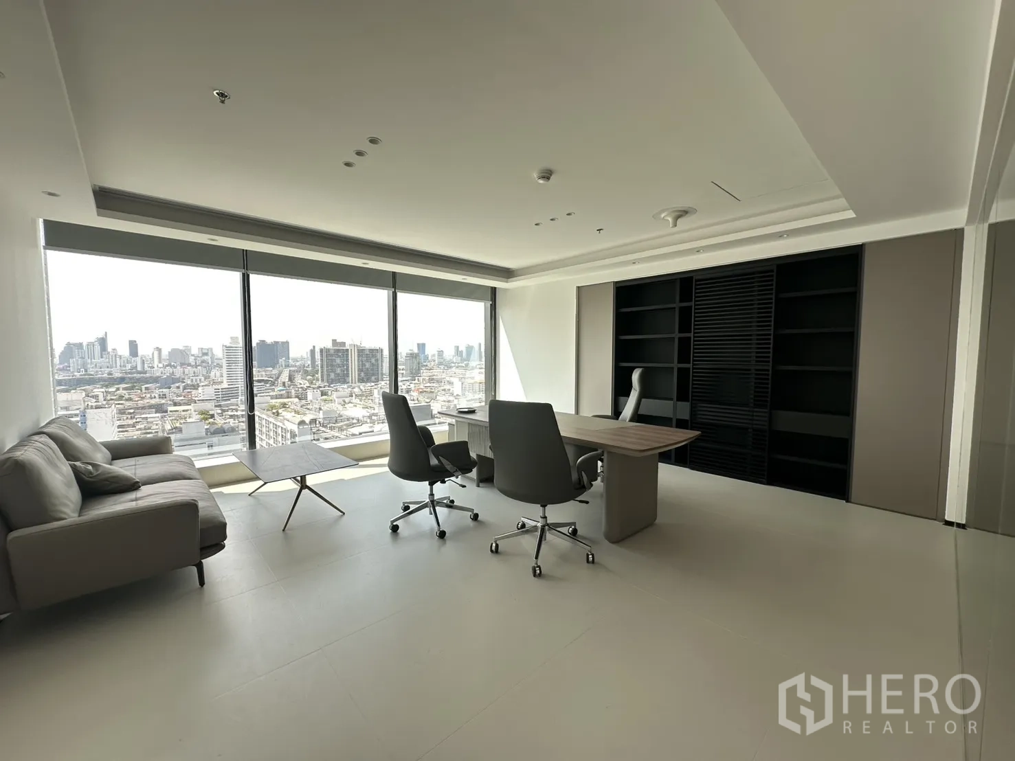 Office Space for rent in Din Daeng, Bangkok - Executive office with sofa, desk, shelving, and wide skyline windows.