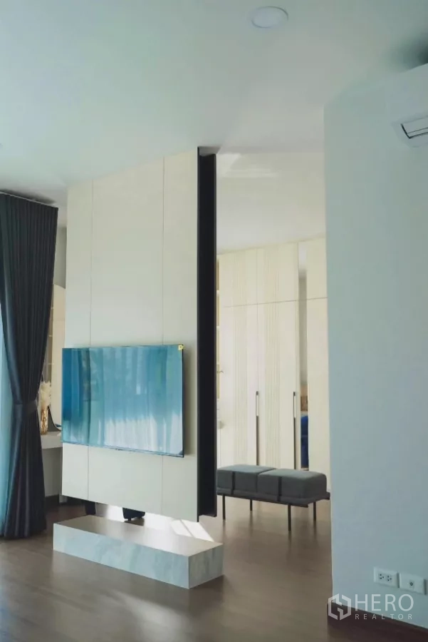 Detached House for rent in Bang Phli, Samut Prakan - TV feature wall dividing the master bedroom with bench and wardrobes.
