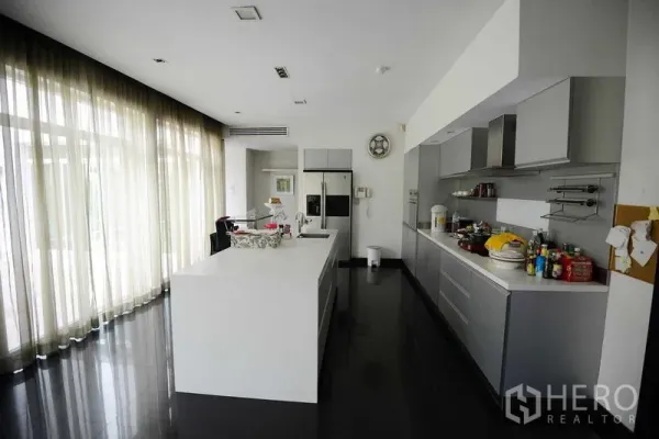 Detached House for sale in Bang Kapi, Bangkok - Bright contemporary kitchen with large island, floor-to-ceiling windows and built-in cabinetry