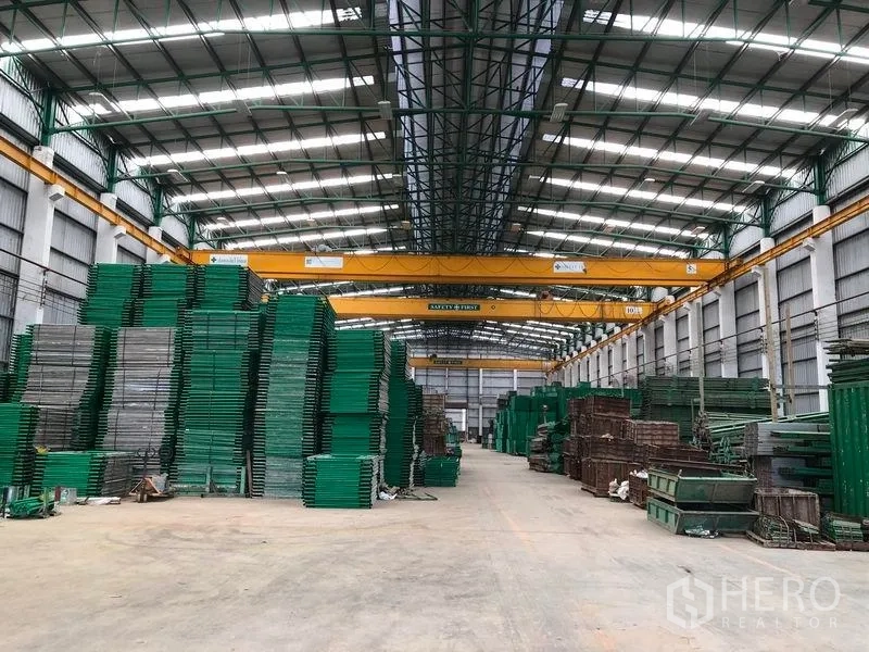 Factory for rent or sale in Lat Lum Kaeo, Pathum Thani - Large factory interior with high‑clearance roof, gantry cranes and organized material racks.