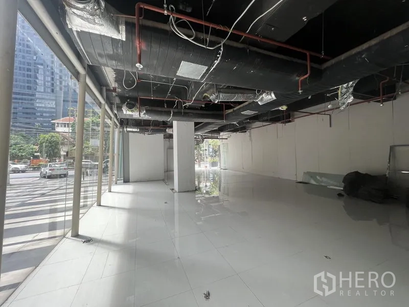 Retail Space for rent in Watthana, Bangkok - Shell retail interior with full-height windows, glossy tile floors and exposed ceiling ductwork.