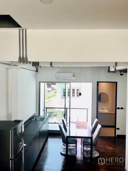 Townhouse for rent or sale in Khlong Toei, Bangkok - Dining corner with glass door to a balcony and an adjacent guest bathroom.