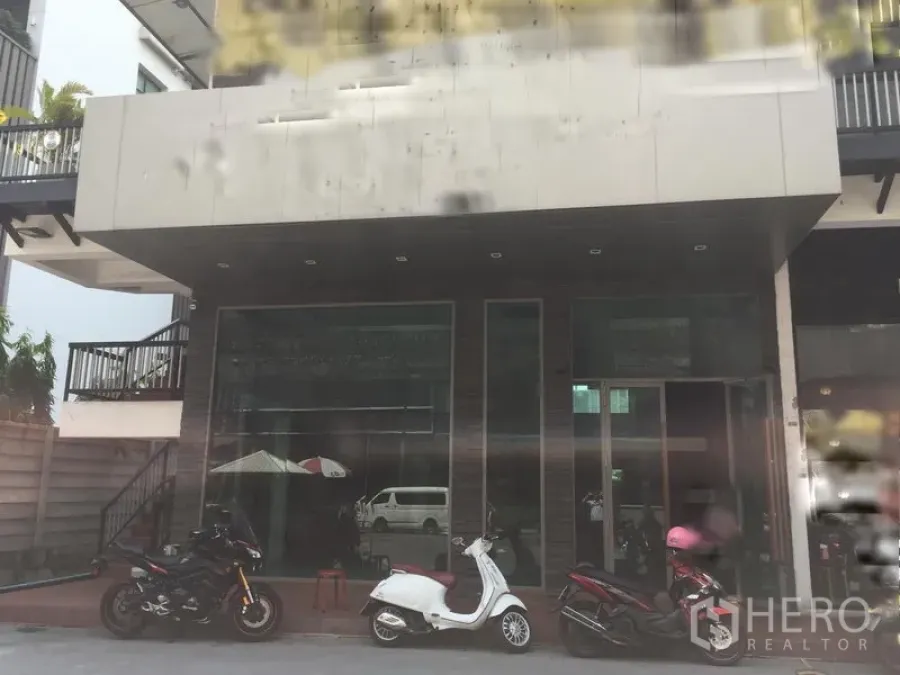Retail Space for rent in Khlong Toei, Bangkok - Ground-floor retail storefront with full-height glass facade and canopy, motorbikes parked in front.