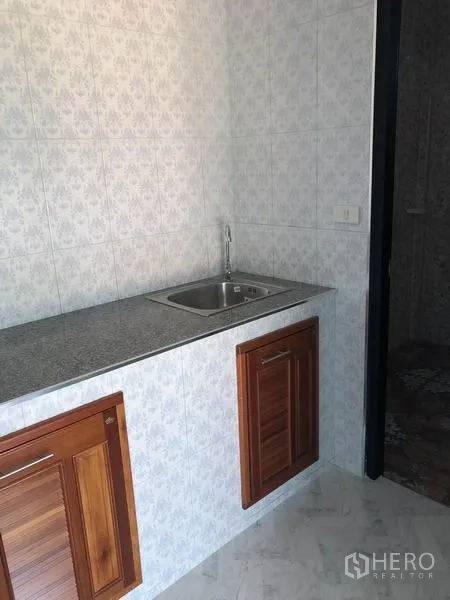 Warehouse for rent or sale in Sai Noi, Nonthaburi - Pantry area with granite countertop, stainless sink and wooden cabinet doors.