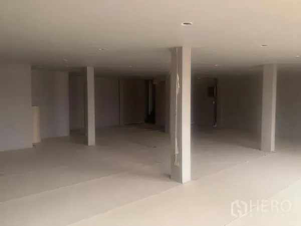 Shophouse for rent in Watthana, Bangkok - Expansive floor with multiple support columns and recessed ceiling lights.
