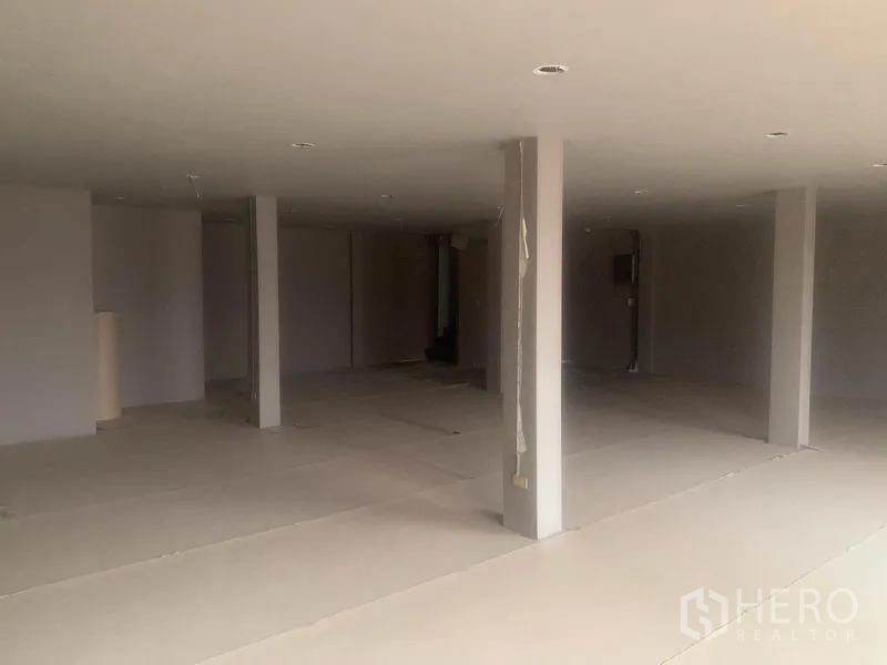 Shophouse for rent in Watthana, Bangkok - Expansive floor with multiple support columns and recessed ceiling lights.