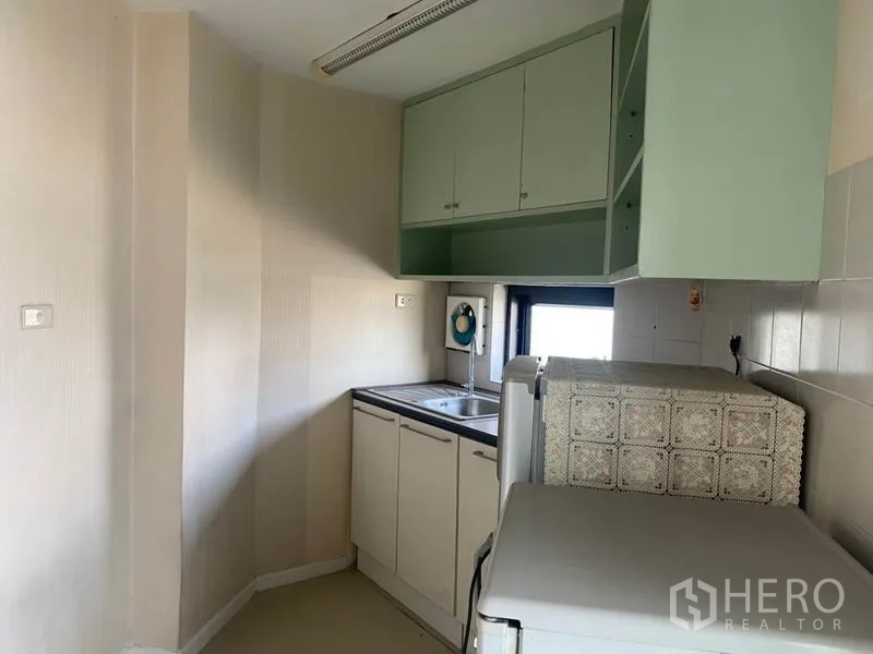 Office Space for rent in Din Daeng, Bangkok - Small pantry kitchenette with sink, upper cabinets and a window.