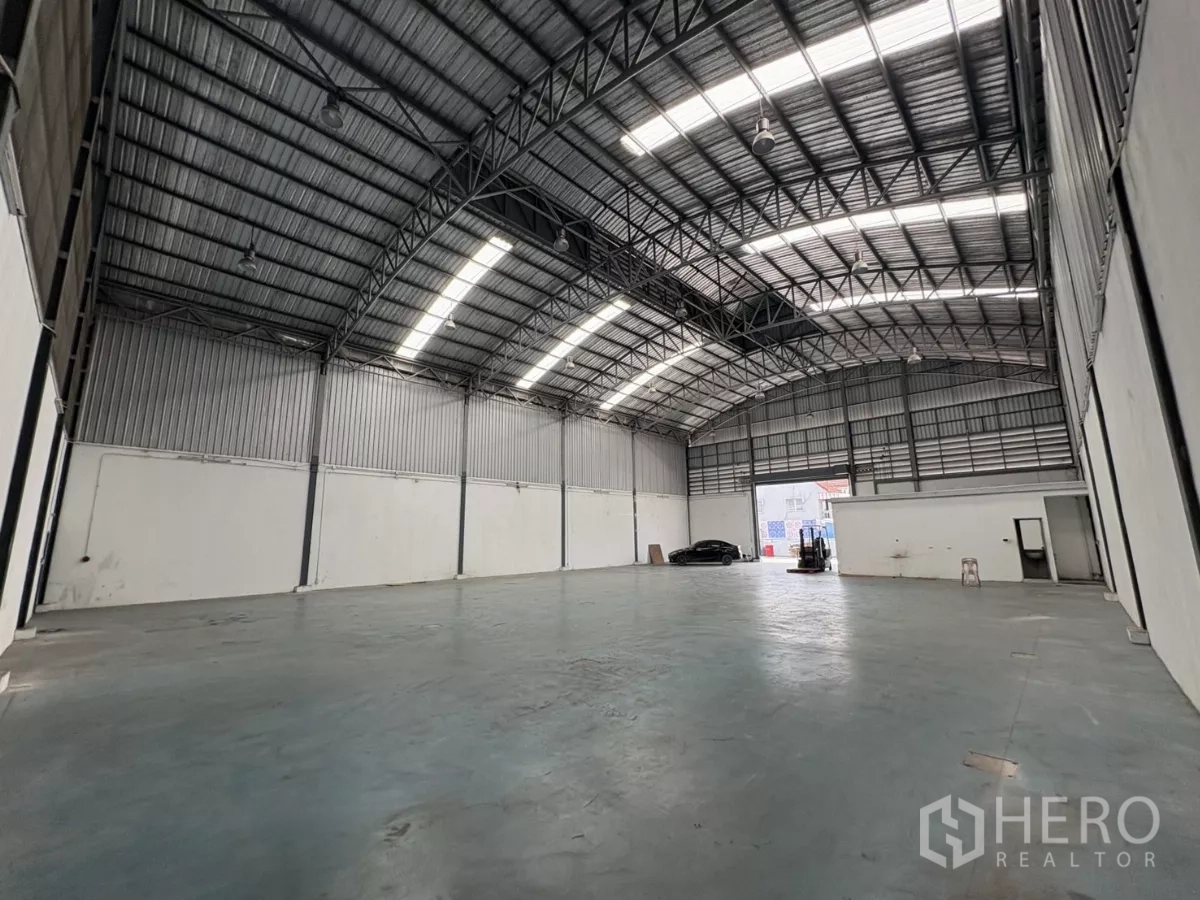 Warehouse for rent in Bang Phli, Samut Prakan - Large storage floor facing the roller door and office block under a curved roof.