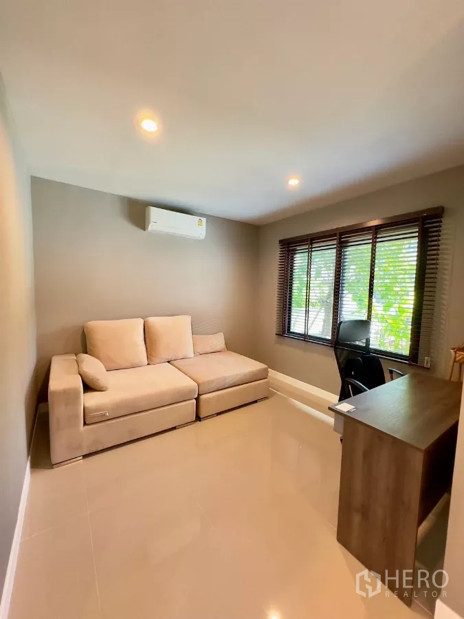 Detached House for rent in Samut Prakan - Multipurpose room set up as a home office with sofa, desk and window blinds.