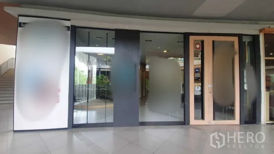 Retail Space for rent in Khlong Toei, Bangkok - Main entrance of the retail space with glass frontage and wooden framed door.