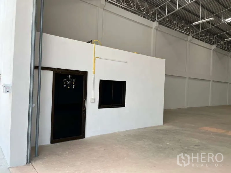 Warehouse for rent in Sam Phran, Nakhon Pathom - Close view of integrated office and restroom module with door and window inside the warehouse.