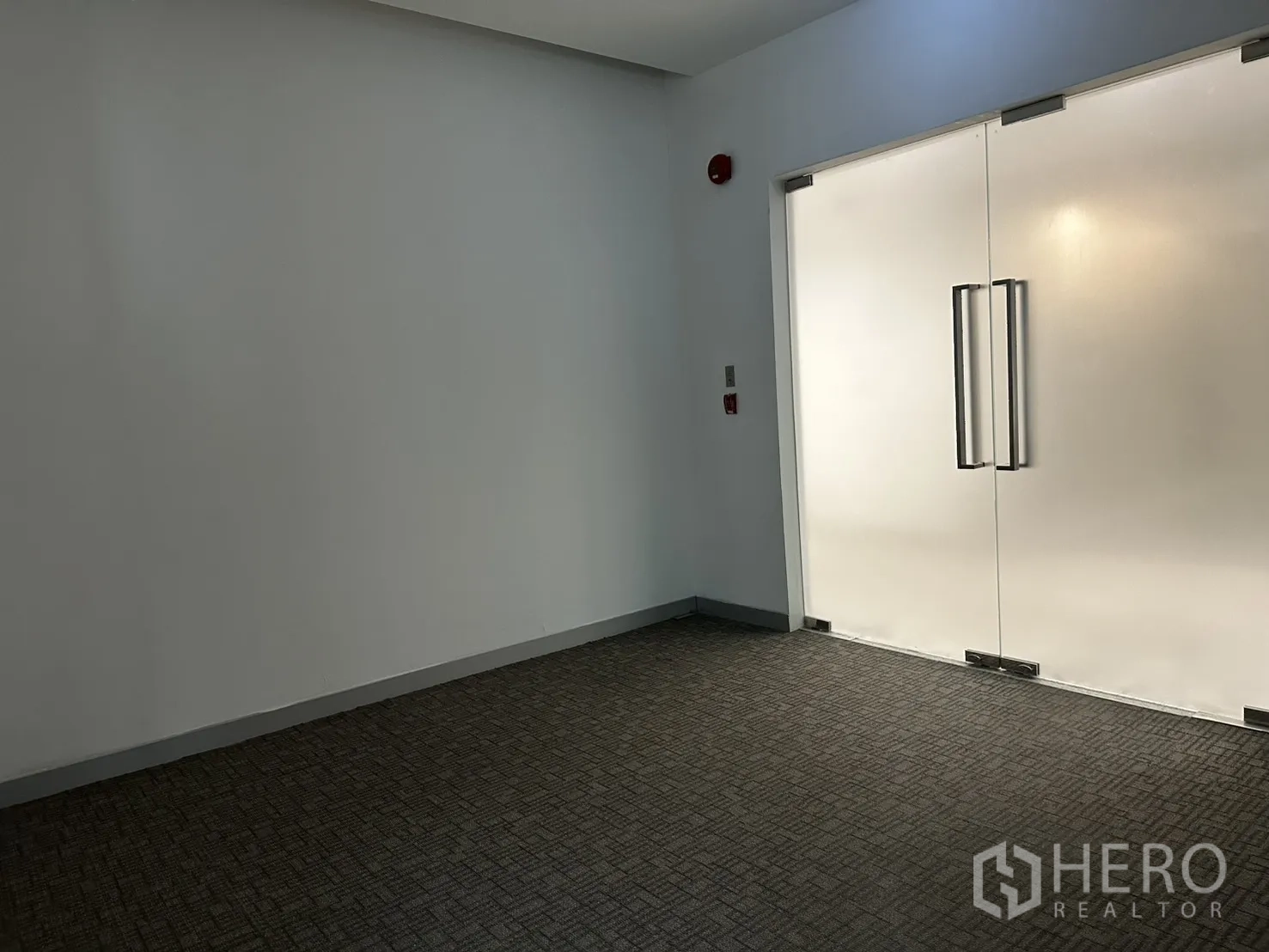 Office Space for rent in Khlong Toei, Bangkok - Carpeted entry with frosted glass double doors and emergency fixtures.