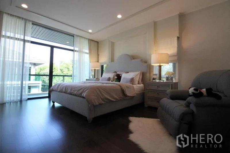 Detached House for rent in Prawet, Bangkok - Bright master bedroom with king bed, large windows and a balcony view over greenery.