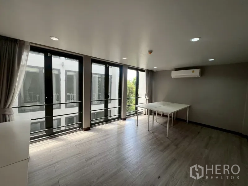 Home Office for rent or sale in Phra Khanong, Bangkok - Multi‑purpose room with curtains, AC and floor‑to‑ceiling windows.