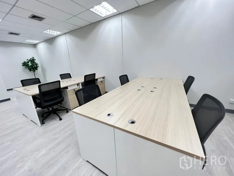 Office Space for rent in Sathon, Bangkok - Open-plan office with long workstations, black mesh chairs and bright ceiling lights.