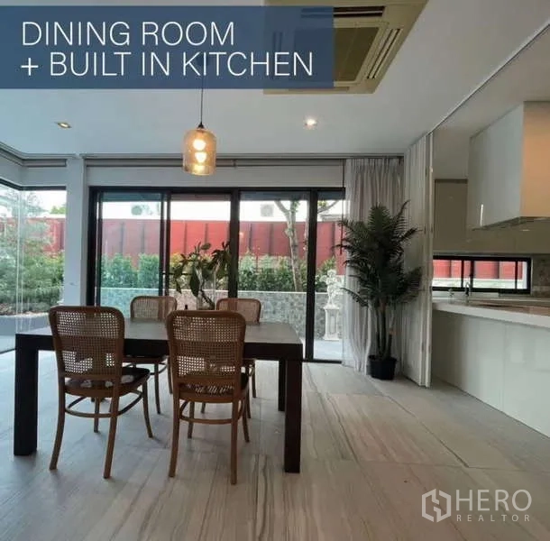 Detached House for sale in Khlong Toei, Bangkok - Dining room with four chairs, pendant light and floor-to-ceiling sliding doors.