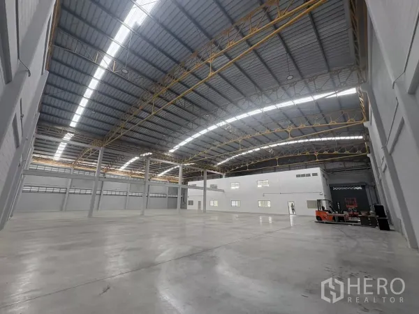 Factory for rent in Bang Phli, Samut Prakan - Wide view of warehouse floor and mezzanine office block under skylights.