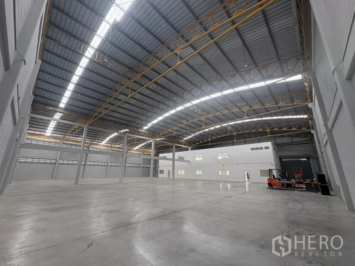 Factory for rent in Bang Phli, Samut Prakan - Wide view of warehouse floor and mezzanine office block under skylights.